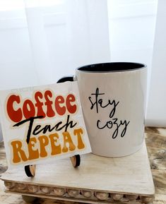 two coffee mugs sitting next to each other on top of a wooden tray with signs