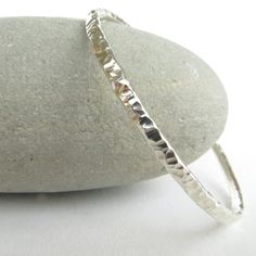 This is a simple silver bangle, forged from 3mm round sterling silver wire and heavily textured with a beaten design. It would make a lovely gift for birthdays, anniversaries or Christmas, and looks great worn as a stacking bangle with your other favourites!   This silver bangle is currently available in a small - 60mm, medium - 65mm, or large - 70mm internal diameter. If you would like it made to order in a different size please let me know. It has been polished to a high shine and really catch Textured Bracelet, Bangle Silver, Line Texture, Bangles Making, Mens Bracelet Silver, Jewelry Bracelets Silver, Sterling Silver Bangle, Stacked Bangles, Silver Bangle Bracelets