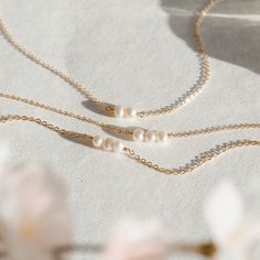 "A reminder that you're always together--whenever, wherever. Choose up to seven pearls to represent your family or friends (or keep it simple with a single pearl just for you)! Every piece is handcrafted and hand-personalized with love in La Conner, WA, using 90% recycled and 100% ethically sourced raw materials from the USA--because it's better that way. Includes free gift-ready packaging (featuring a care card and traditional letterpress goodies made by my dad)!  MATERIALS: * Gold = 14k gold filled * Silver = sterling silver * Rose gold = 14k rose gold filled DETAILS: * Genuine freshwater pearls * Choose 1-7 pearls AT CHECKOUT: * If you chose \"other\" for length, specify which length you'd like in a note.  * Select expedited shipping (and add a note with your ideal delivery date) if you 14k Gold Filled Pearl Chain Jewelry For Anniversary, Delicate Yellow Gold Pearl Necklace For Anniversary, Delicate Everyday Pearl Necklace In 14k Gold, Delicate Everyday 14k Gold Pearl Necklace, Everyday 14k Gold Pearl Necklace, Personalized Dainty Pearl Necklace For Anniversary, Minimalist White Jewelry For Anniversary Gift, Minimalist White Jewelry For Anniversary, Anniversary Pearl Chain Jewelry