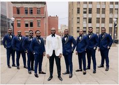 a group of men in tuxedos standing next to each other on a rooftop