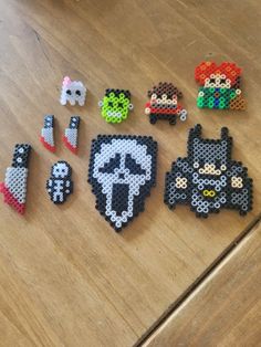 several pixel art magnets sitting on top of a wooden table