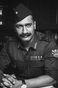 a black and white photo of a man in uniform with a moustache on his face