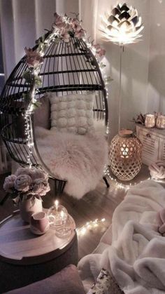 a bedroom with white fur and lights on the walls, a birdcage hanging from the ceiling