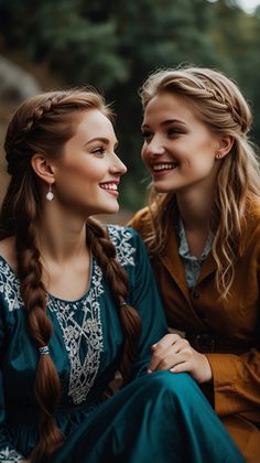 two young women sitting next to each other smiling and looking into each other's eyes