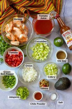 the ingredients to make shrimp salad laid out on a white counter top with limes, tomatoes, celery, onion, and jalapenos