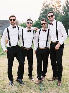 a group of men standing next to each other on top of a grass covered field