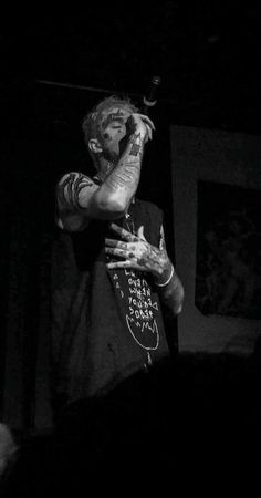 a man with tattoos on his arm holding a skateboard