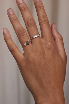 a woman's hand with two rings on it