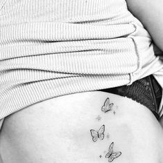 a woman's stomach with three butterflies on it