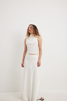 This top is made of jersey and features a sleeveless design. It has a bodycon fit and shoulders with a draped detail. This top features a button closure. White Fitted Draped Top, Future Fashion, A Button, Jersey Top, Women Empowerment, Off White, Design