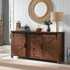 a wooden dresser sitting next to a mirror on top of a white wall in a living room