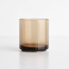 a glass candle holder sitting on top of a white table