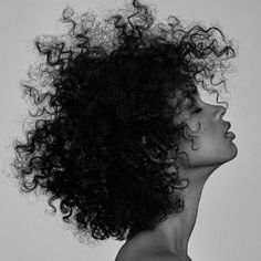 a black and white photo of a woman with curly hair