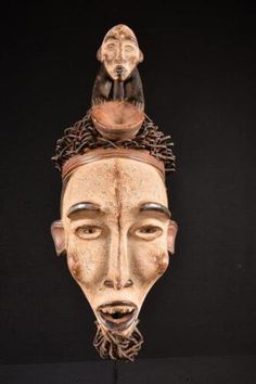 an african mask is hanging on the wall