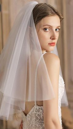 a woman in a wedding dress with a veil on her head