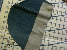 a piece of fabric is being sewn on with scissors and rulers next to it