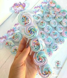 a hand is holding a bunch of pastel colored hair clips in front of a white background