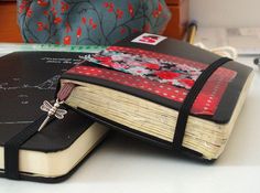 an open book with a cross on it sitting on top of a table next to other books