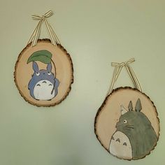 two pieces of wood hanging on the wall with cartoon characters painted on them and one has a totoro