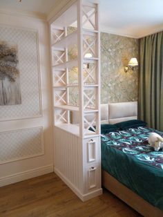 a bed room with a neatly made bed and a book shelf next to the bed