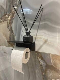 a black and white marble bathroom with an electric toothbrush holder on the wall next to it