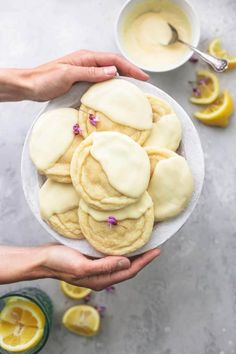 two hands holding a plate of lemon cookies