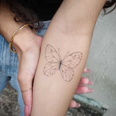 a woman's arm with a butterfly tattoo on the left side of her arm