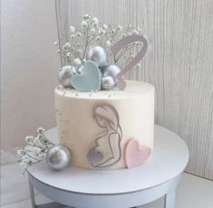 there is a white cake with pink and blue decorations on the top, sitting on a table