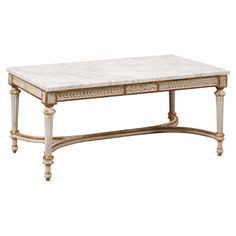 a white marble top coffee table with gold trimming