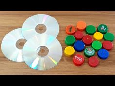 two cd's sitting on top of a wooden table next to markers and pens