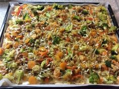 a casserole dish with broccoli, carrots and other vegetables