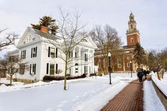 two people walking down a sidewalk in the snow