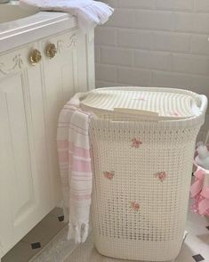 a white laundry basket sitting next to a sink