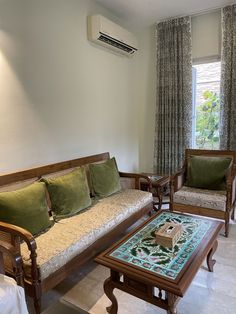 a living room with two couches and a coffee table in front of a window