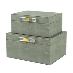 two gray boxes with gold handles are stacked on top of each other