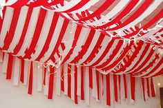 red and white striped fabric hanging from the ceiling in a room with lights on it