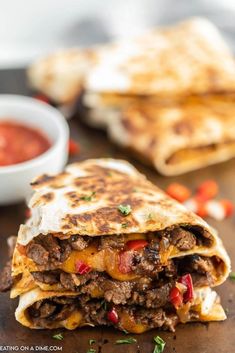 two quesadillas stacked on top of each other with salsa in the background