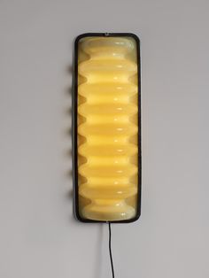 a wall light that is on the side of a wall with wires attached to it