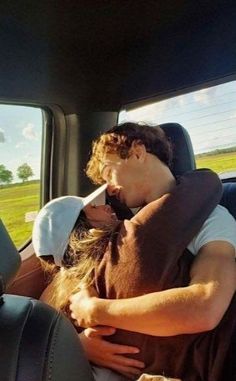 a man sitting in the back seat of a car with his arm wrapped around a woman