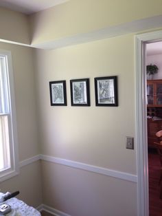 three framed pictures are hanging on the wall