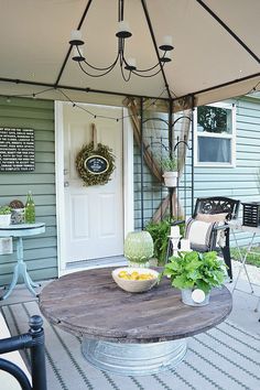 a patio with an umbrella over it and some plants on the table in front of the door