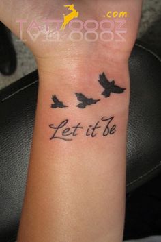 a woman's wrist tattoo with birds flying in the sky and let it be written on