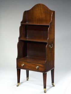 an antique wooden bookcase with brass handles