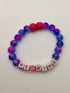 Be Kind - Pink Swarovski crystal between the words upcycled from a lone vintage earring; pink wooden beads (note minor asymmetry), and pink/blue plastic beads This bracelet fits an adult small/medium wrist and is made with an elastic that easily stretches over the hand. The beads used are repurposed from thrifted materials and therefore have minor imperfections. Please see each picture for details and read all notes below! Note:  - The elastic is firmly tied with singed ends and the knot remains concealed within a bead hole during wear. If the knot slides out of the bead hole and is visible, it can easily be gently pulled back into the hole and re-concealed. - These bracelets are made from different combinations of repurposed and new materials. If you're looking for each bead to be free of Diy Kandi Bracelets, Diy Kandi, Vintage Earring, Kandi Bracelets, Pink Swarovski, Elastic Bracelet, Plastic Beads, The Knot, Be Kind