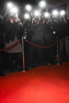 a group of people standing on top of a red carpet