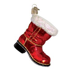 a red boot ornament hanging on a white wall with a gold trimming