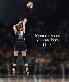 a woman in black and white uniform jumping up to hit a basketball with her right hand