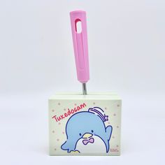 a toothbrush holder with a pink handle and a blue dolphin on it's side