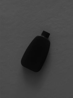 a black bottle sitting on top of a snow covered ground