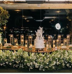 a wedding cake sitting on top of a table surrounded by greenery